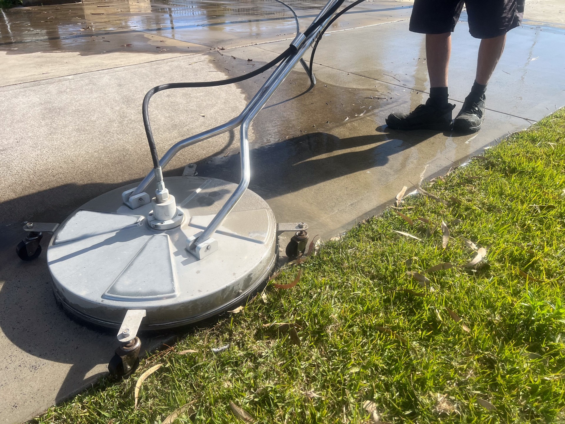 Worker using a floor and surface pressure washer cleaner