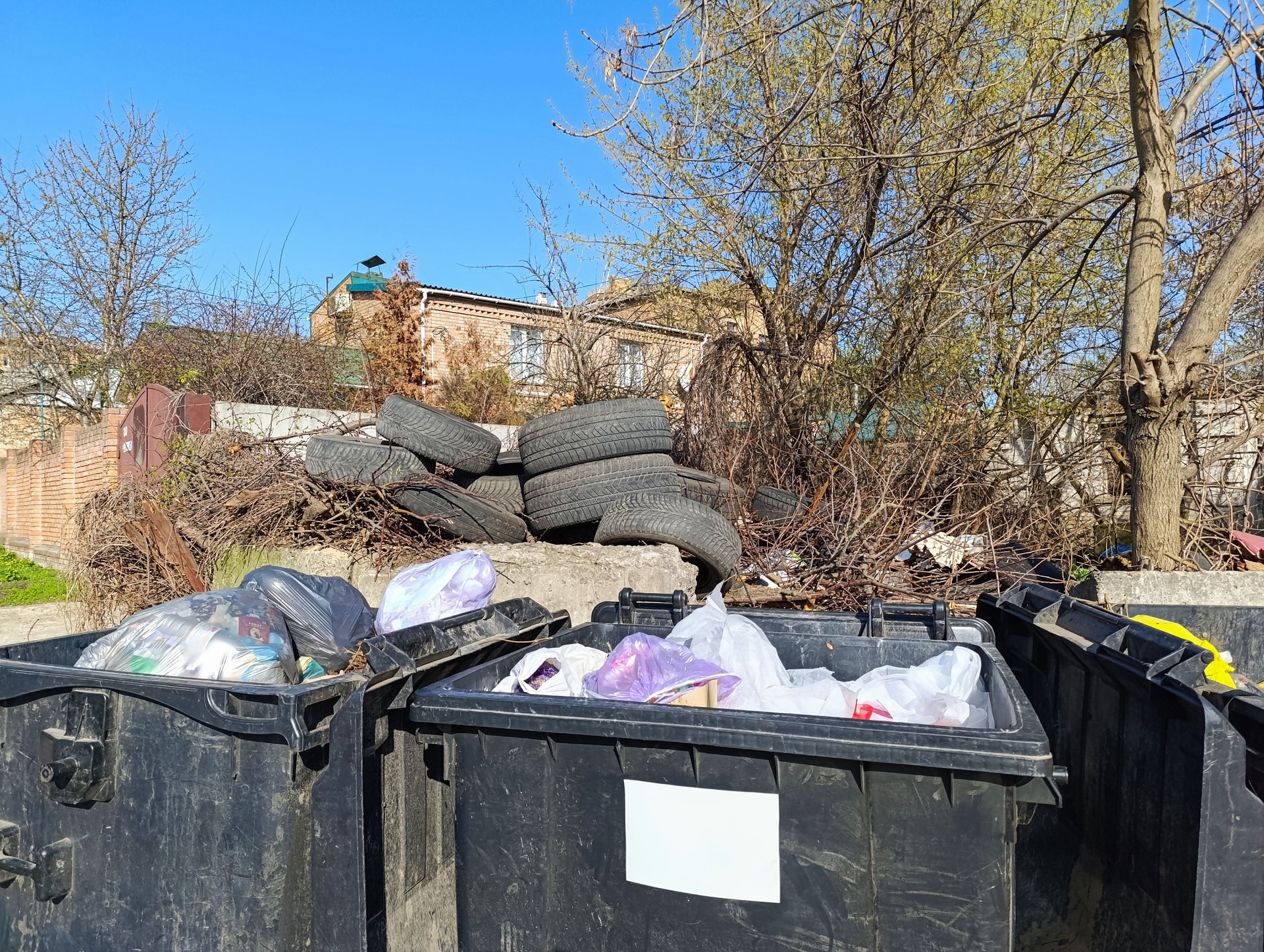 Overflowing personal trash bins, car tires in a trash bin. Waste disposal